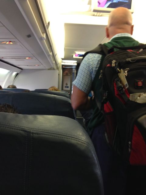 Businessman with backpack in Delta first class cabin