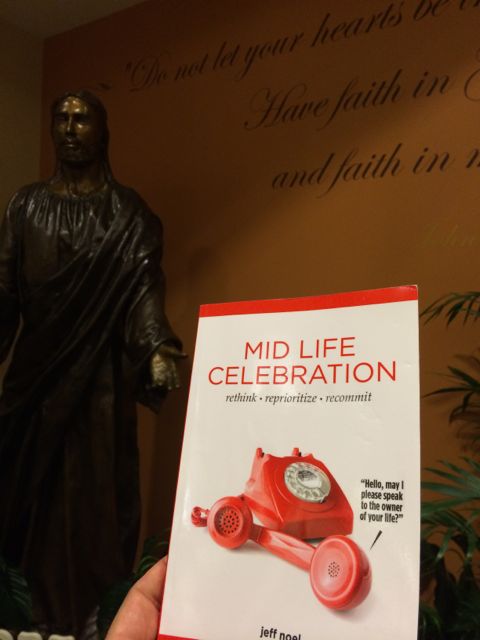 Mid Life Celebration book with Jesus statue in background