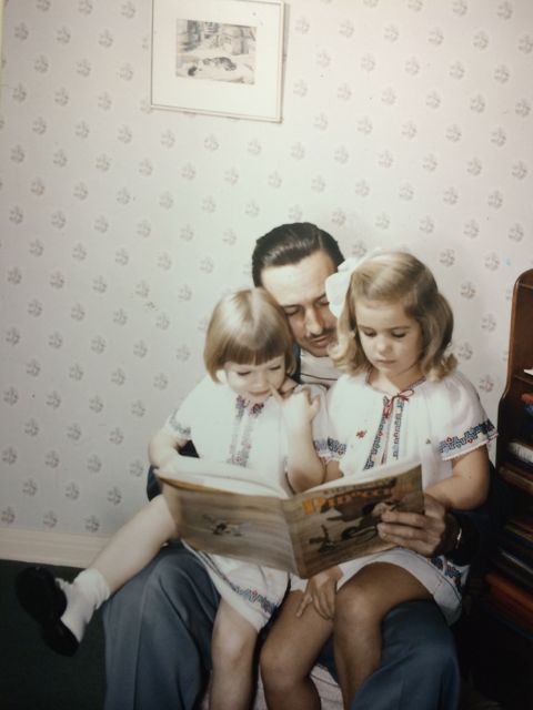 Walt Disney with his daughters sitting on his lap
