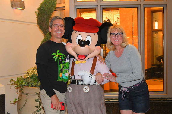 Married couple posing with Mickey Mouse