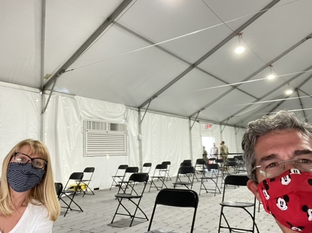 masked couple in large empty tent