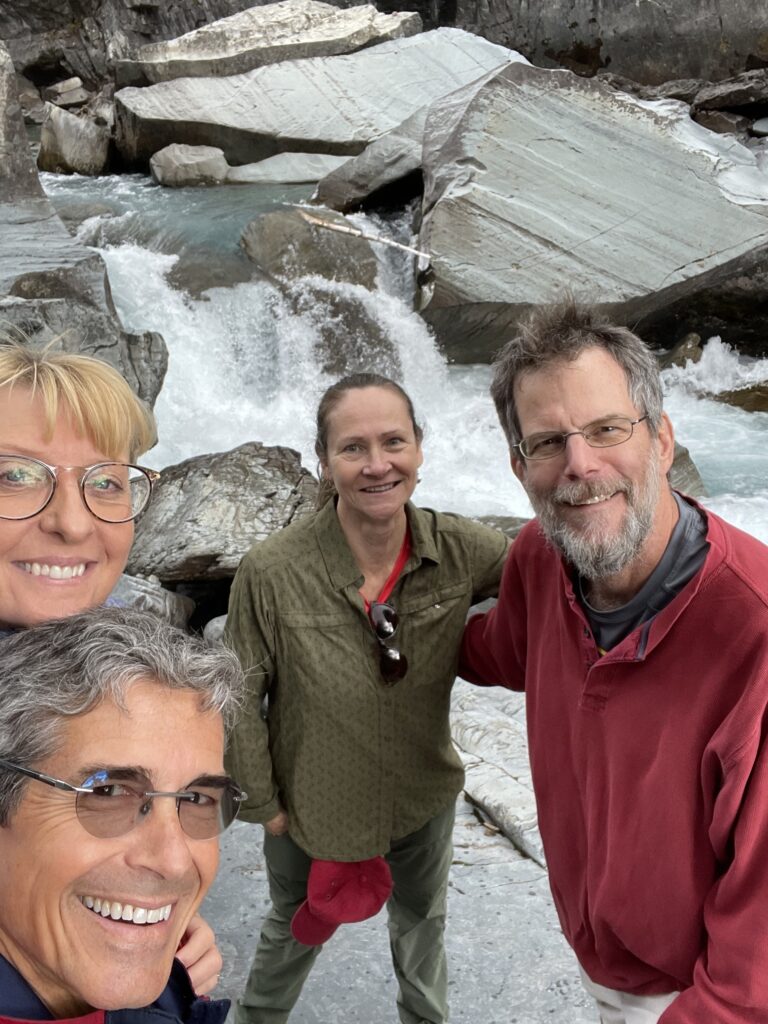 Two couples smiling by mountain creek