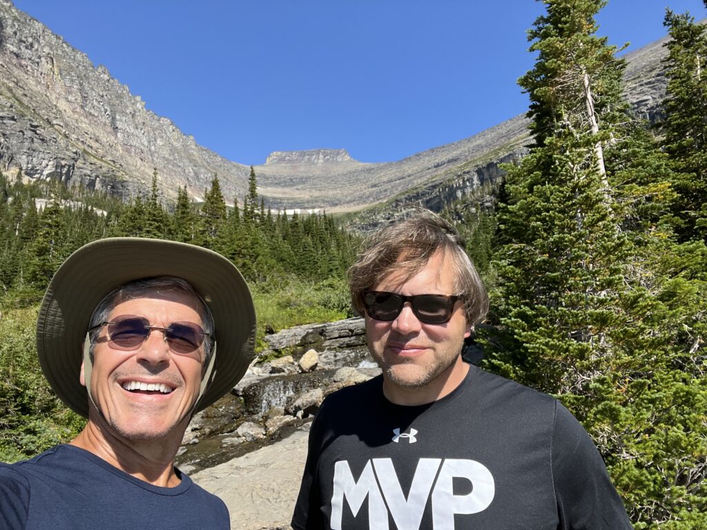 Two men with a mountain behind them