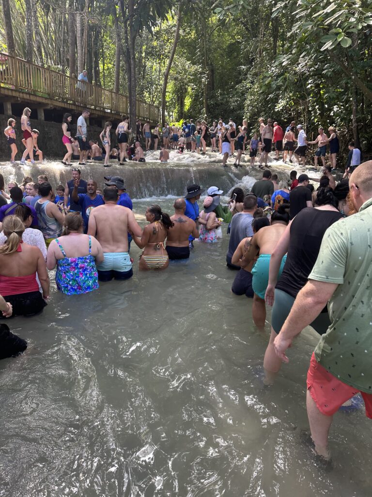 Lines of people walking through a water fall