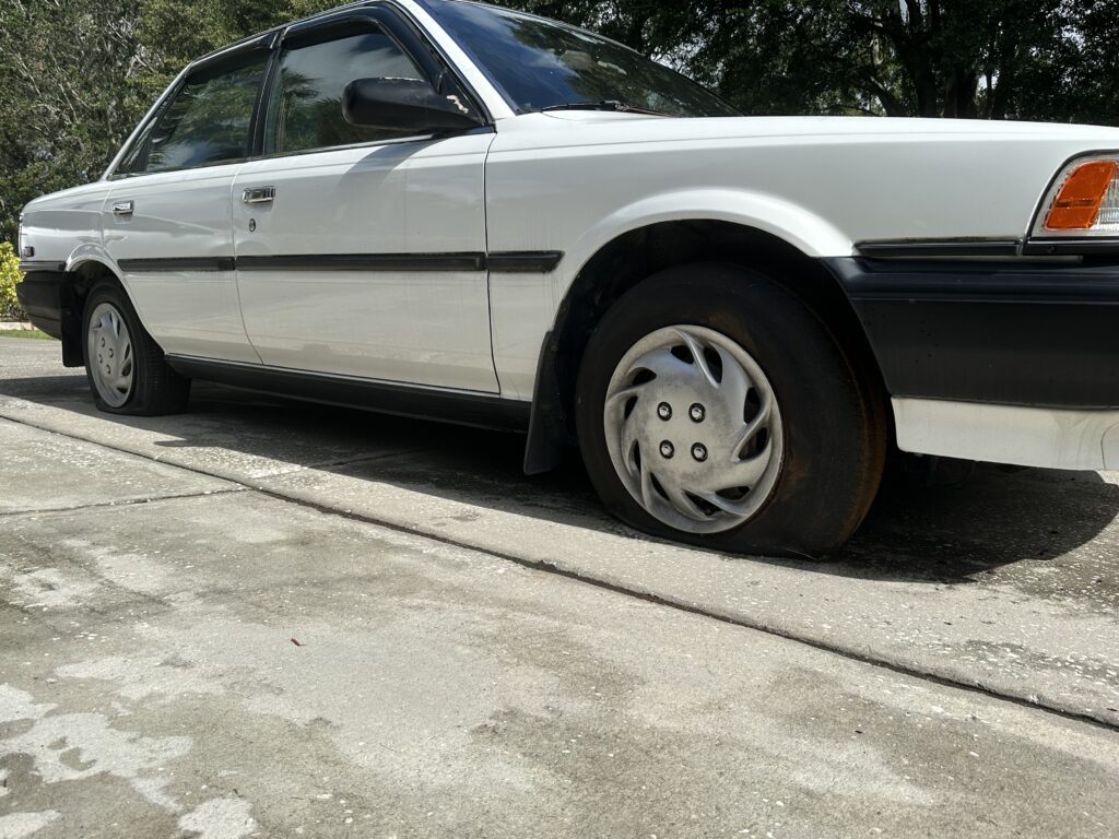Old car with two flat tires