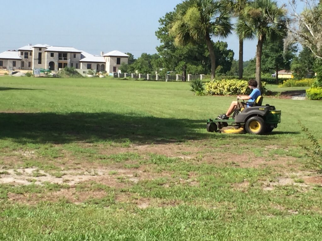 Teen driving riding lawn mower