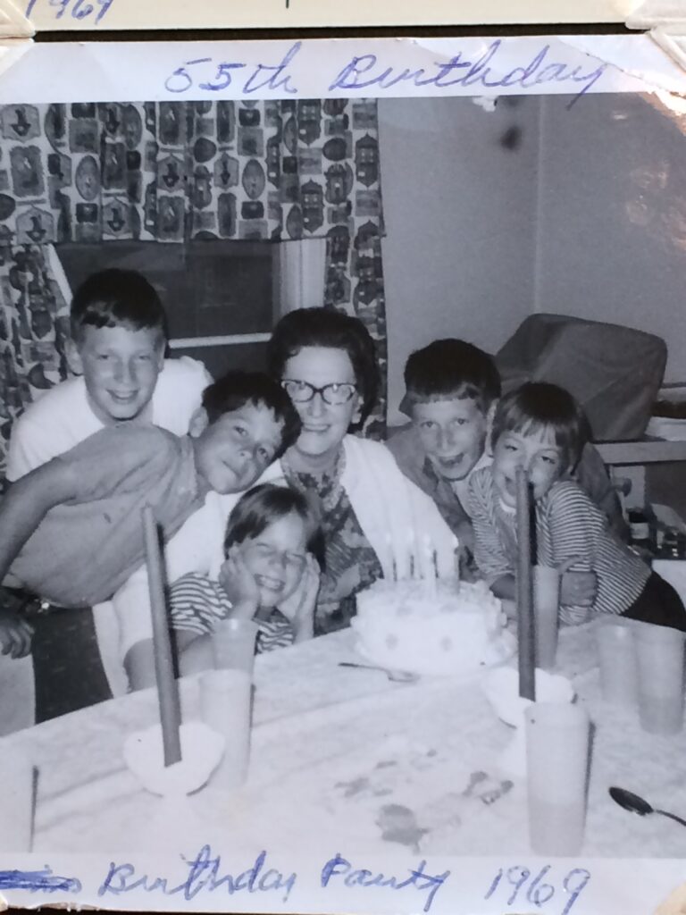 black and white photo five grandchildren surrounding grandma