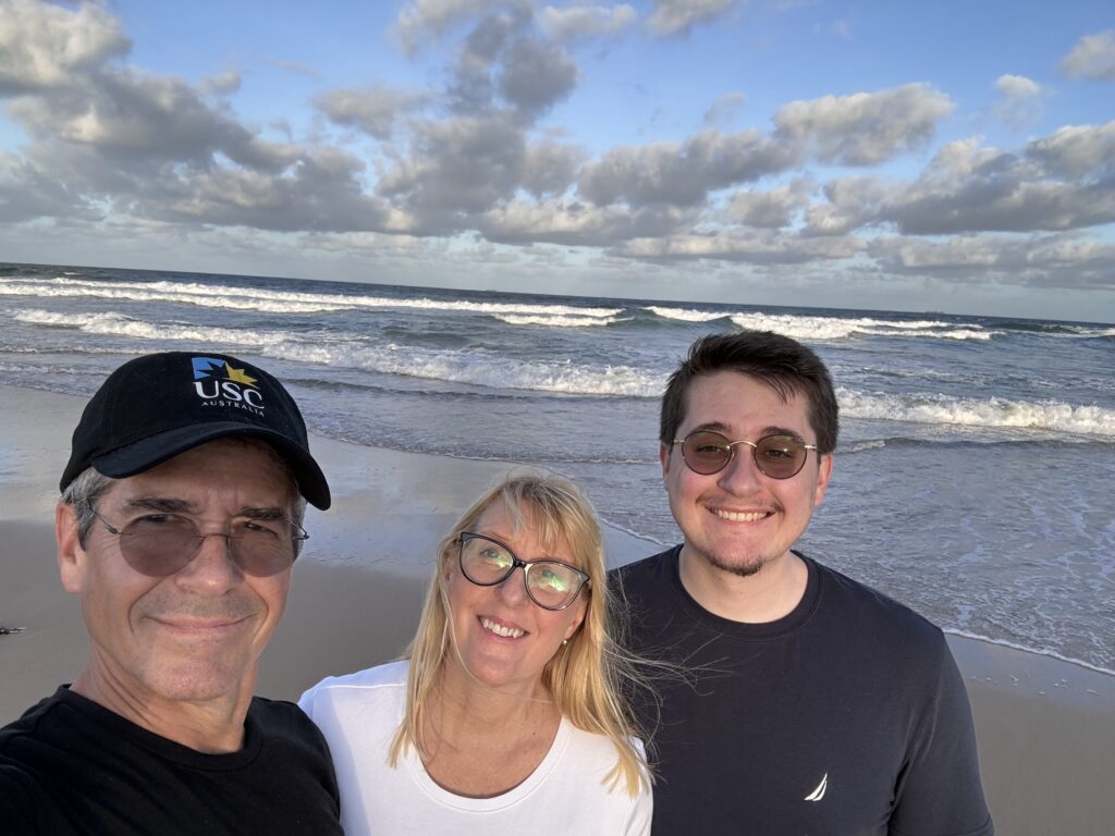 Three people posing at beach