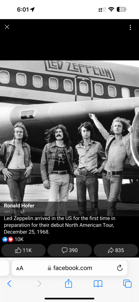 Led Zeppelin standing beside their Jet