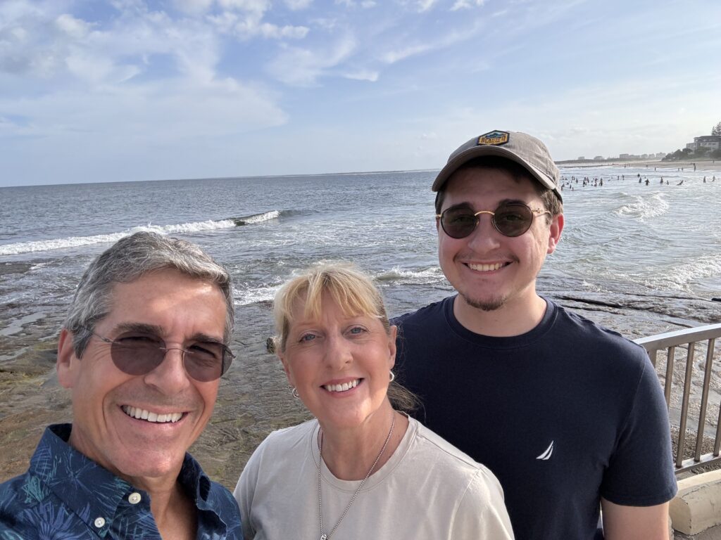 Three people posing at the beach