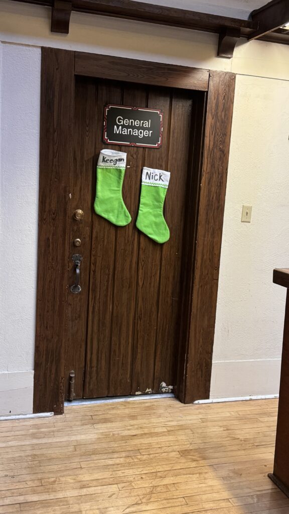 Two green Christmas stockings on a wooden door