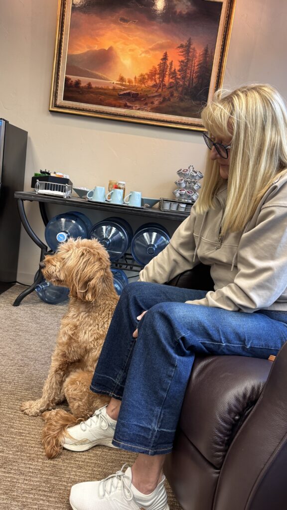 Sitting on a chair with a dog on her feet