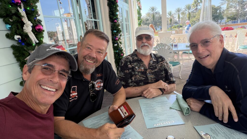 four senior citizens at cafe table