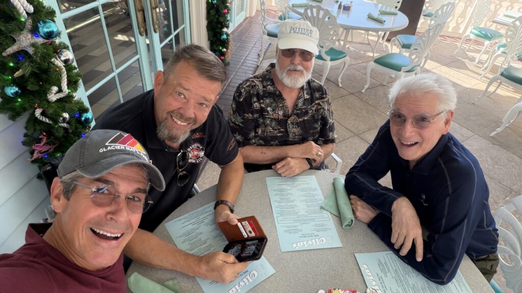 four senior citizens at cafe table