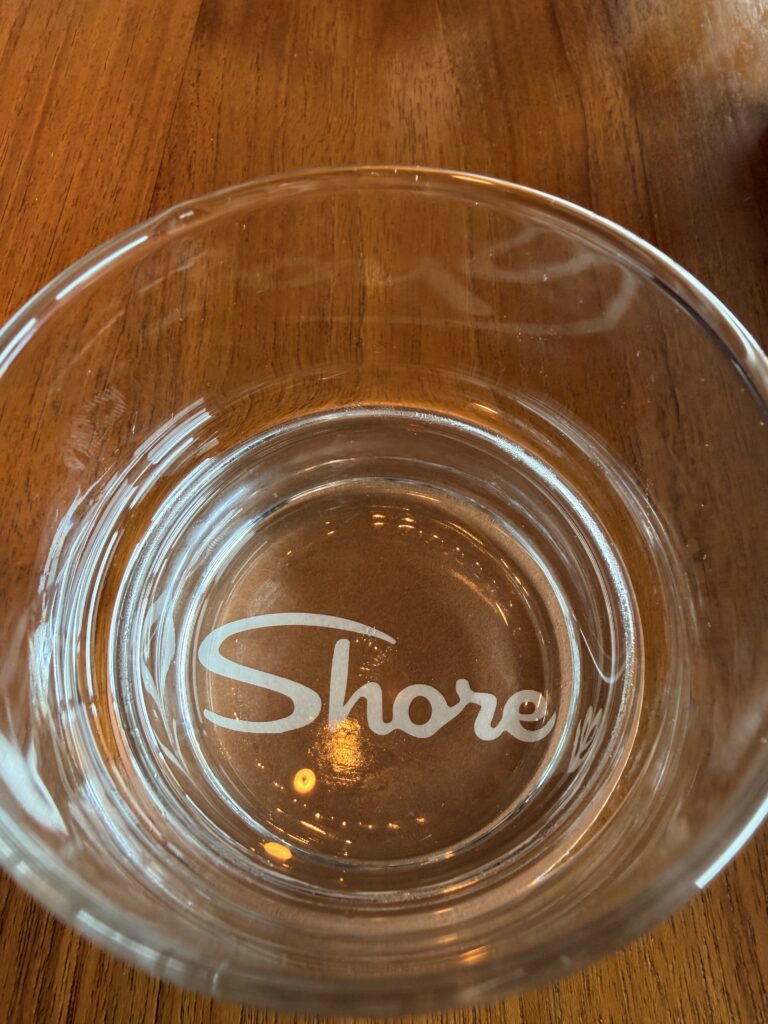 glass with the word Shore inscribe on the bottom